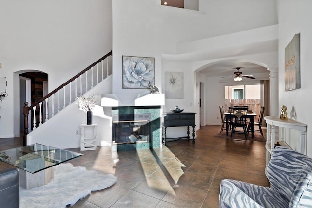 1837 Avenida Sevilla, Oceanside, CA 92056 - living area with arched walkways, a high ceiling, a ceiling fan, a fireplace, and stairway