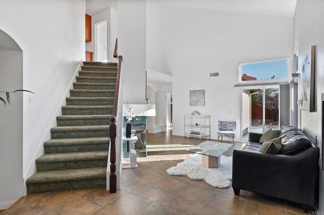 1837 Avenida Sevilla, Oceanside, CA 92056 - living room featuring stairway, a towering ceiling, stone tile floors, and arched walkways