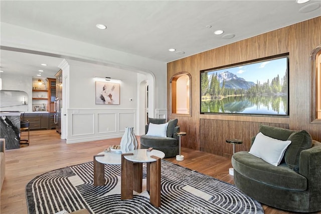 7 Kent Ct, Ladera Ranch, CA 92694 - living area with arched walkways, light wood-style flooring, recessed lighting, and wood walls