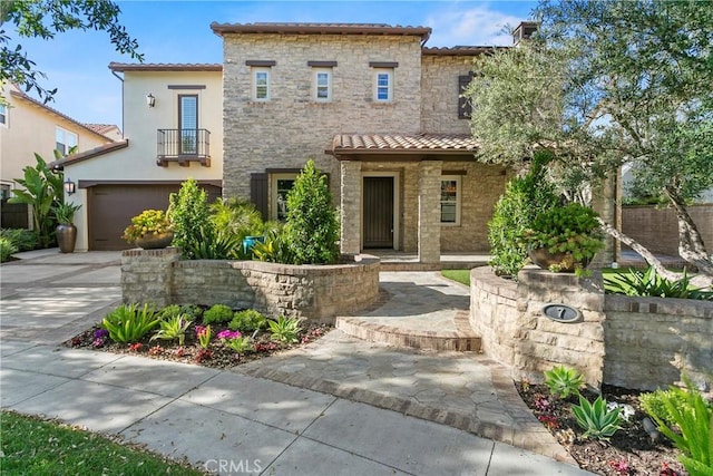 7 Kent Ct, Ladera Ranch, CA 92694 - mediterranean / spanish-style house with a tile roof, stone siding, an attached garage, a balcony, and stucco siding