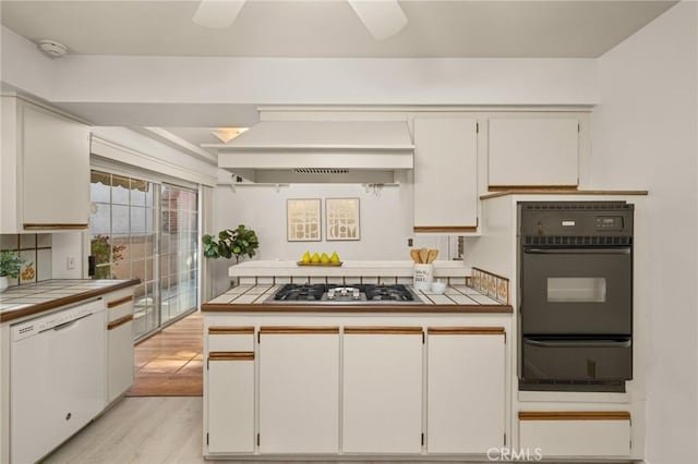 12751 9th St, Garden Grove, CA 92840 - kitchen with white dishwasher, black oven, a warming drawer, stainless steel gas cooktop, and tile countertops