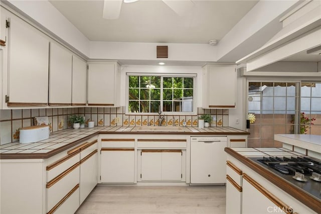 12751 9th St, Garden Grove, CA 92840 - kitchen with white dishwasher, tile counters, tasteful backsplash, stainless steel gas stovetop, and light wood finished floors