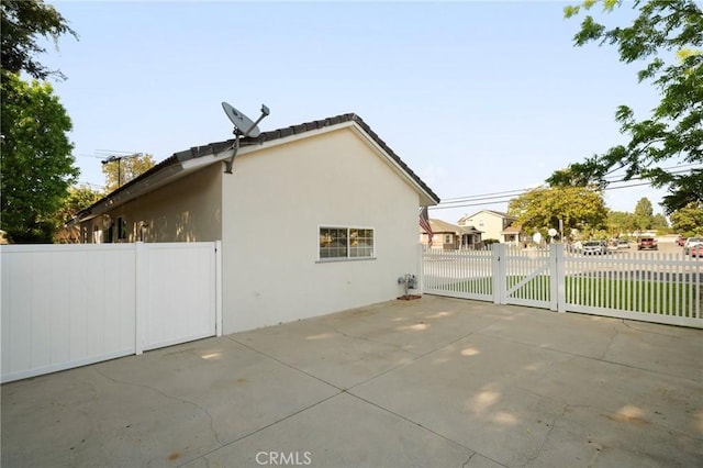 12751 9th St, Garden Grove, CA 92840 - view of side of home with stucco siding, a gate, and a patio
