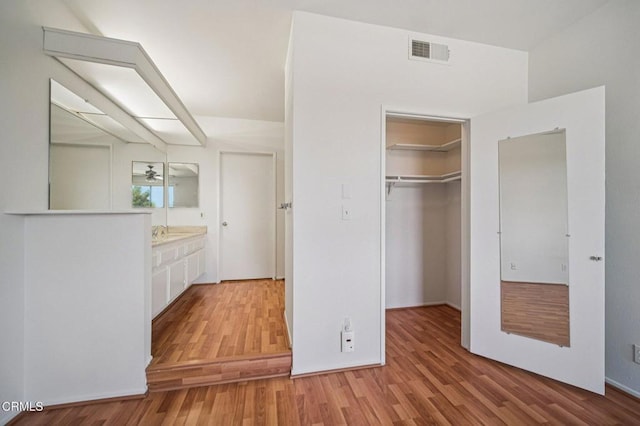 7211 Cozycroft Ave Unit 40, Winnetka, CA 91306 - unfurnished bedroom featuring light wood finished floors, a closet, and a walk in closet