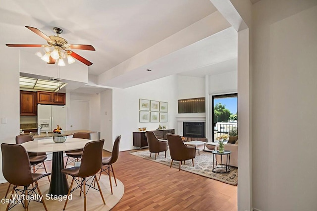7211 Cozycroft Ave Unit 40, Winnetka, CA 91306 - dining room featuring light wood finished floors, a glass covered fireplace, and ceiling fan