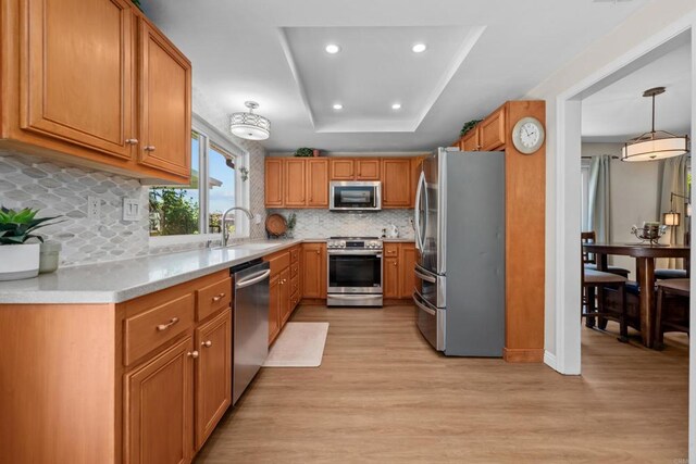764 Barsby St, Vista, CA 92084 - kitchen with appliances with stainless steel finishes, light wood finished floors, a raised ceiling, light countertops, and brown cabinetry