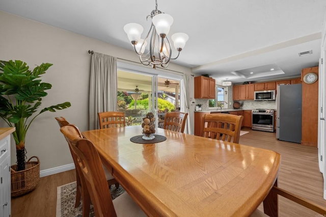 764 Barsby St, Vista, CA 92084 - dining area with a chandelier, a raised ceiling, and light wood finished floors