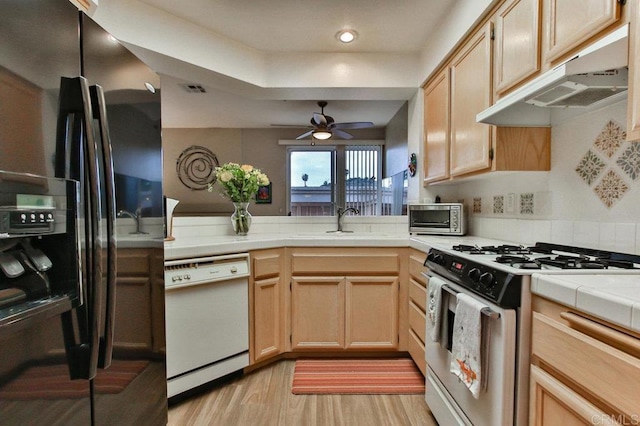 11368 Via Rancho San Diego Unit C, El Cajon, CA 92019 - kitchen with black fridge, range with gas stovetop, white dishwasher, under cabinet range hood, and tile counters