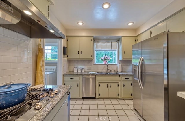 430 N Canyon Blvd, Monrovia, CA 91016 - kitchen featuring stainless steel appliances, under cabinet range hood, washer / dryer, light tile patterned flooring, and cream cabinets