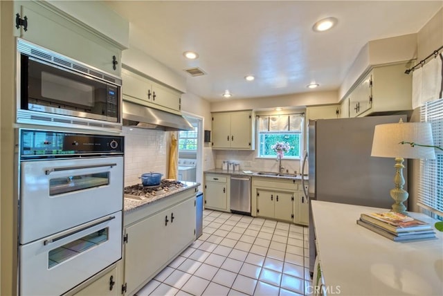 430 N Canyon Blvd, Monrovia, CA 91016 - kitchen with under cabinet range hood, appliances with stainless steel finishes, light countertops, tasteful backsplash, and light tile patterned flooring