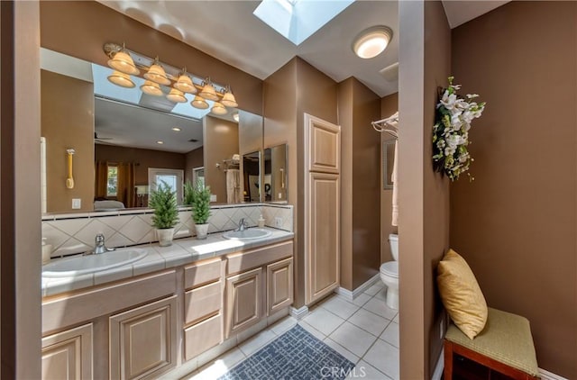 430 N Canyon Blvd, Monrovia, CA 91016 - bathroom featuring decorative backsplash, double vanity, a skylight, and tile patterned floors