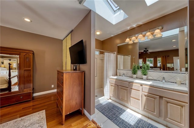 430 N Canyon Blvd, Monrovia, CA 91016 - ensuite bathroom featuring a skylight, tiled shower, double vanity, wood finished floors, and ceiling fan