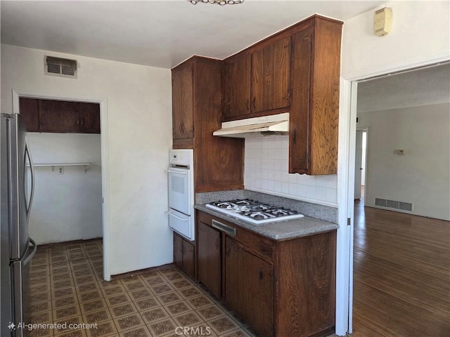 11505 Elmhurst Dr, Norwalk, CA 90650 - kitchen featuring white appliances, under cabinet range hood, backsplash, a warming drawer, and dark wood-style flooring