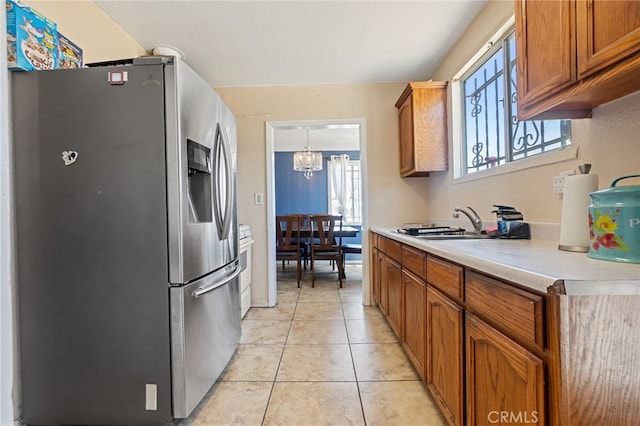 1445 W 155th St, Compton, CA 90220 - kitchen with stainless steel fridge, light countertops, brown cabinets, and light tile patterned floors