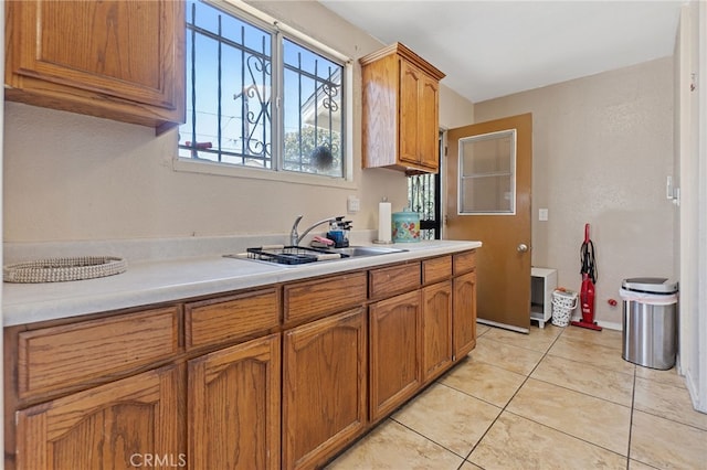 1445 W 155th St, Compton, CA 90220 - kitchen with light countertops, brown cabinetry, and light tile patterned flooring