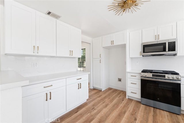 18085 Golden Leaf Ln, Riverside, CA 92504 - kitchen featuring appliances with stainless steel finishes, light countertops, white cabinets, and light wood finished floors