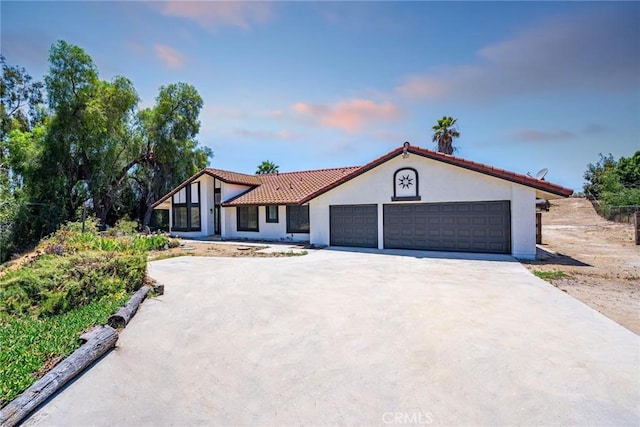 18085 Golden Leaf Ln, Riverside, CA 92504 - mediterranean / spanish home featuring an attached garage, stucco siding, driveway, and a tiled roof