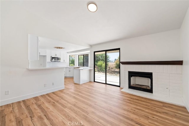 18085 Golden Leaf Ln, Riverside, CA 92504 - unfurnished living room with a fireplace, light wood-style flooring, and lofted ceiling