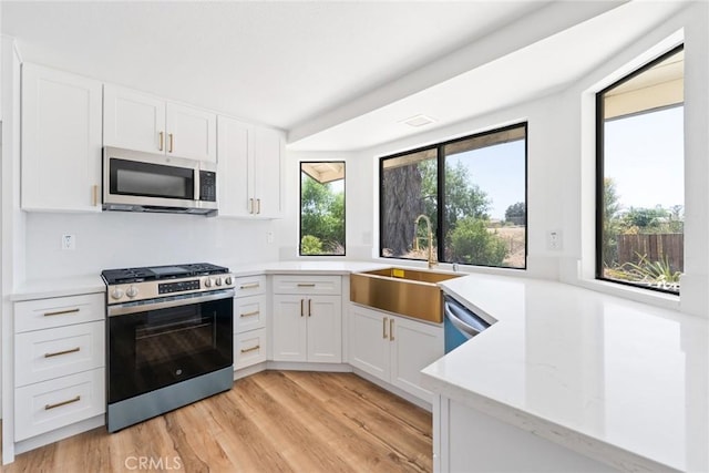 18085 Golden Leaf Ln, Riverside, CA 92504 - kitchen featuring stainless steel appliances, white cabinetry, and light wood-style floors