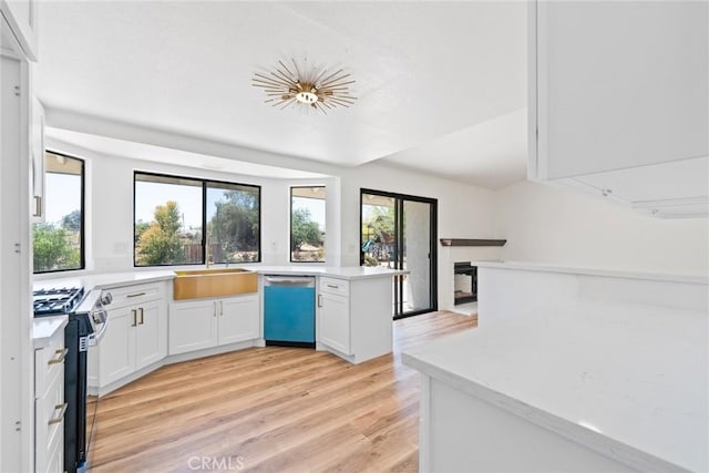 18085 Golden Leaf Ln, Riverside, CA 92504 - kitchen with dishwasher, range with gas cooktop, light wood-style flooring, white cabinetry, and a peninsula