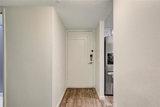 550 Orange Ave Unit 212, Long Beach, CA 90802 - hallway featuring light wood-style floors, a textured ceiling, and a textured wall