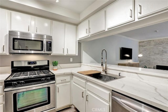 550 Orange Ave Unit 212, Long Beach, CA 90802 - kitchen featuring appliances with stainless steel finishes, ornamental molding, white cabinets, and light stone countertops