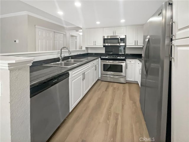 1564 Tanglewood Ln Unit 11, Escondido, CA 92029 - kitchen featuring appliances with stainless steel finishes, dark countertops, a peninsula, white cabinetry, and recessed lighting