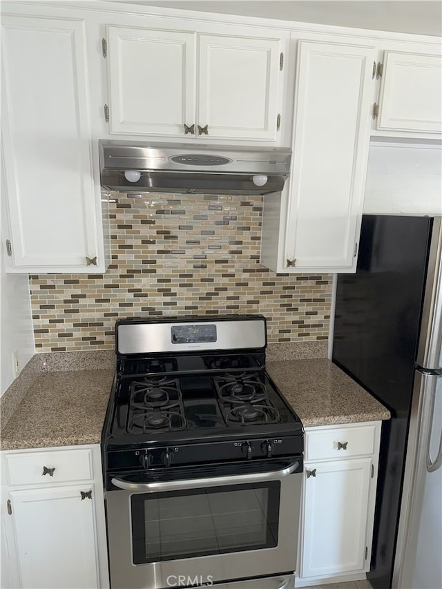 3031 S Denison Ave, San Pedro, CA 90731 - kitchen featuring stainless steel appliances, under cabinet range hood, white cabinetry, decorative backsplash, and light stone countertops