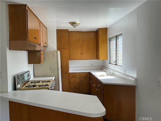 6259 Coldwater Canyon Ave Unit 13, North Hollywood, CA 91606 - kitchen with white range with gas cooktop, exhaust hood, light countertops, brown cabinetry, and a peninsula