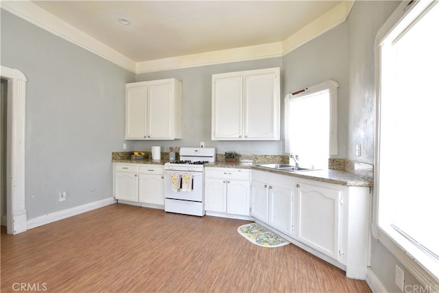 340 E Main St, San Jacinto, CA 92583 - kitchen featuring white gas range oven, white cabinets, healthy amount of natural light, and light wood finished floors