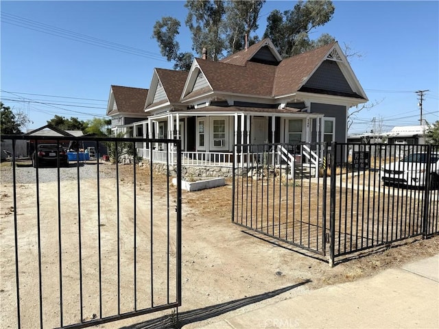 340 E Main St, San Jacinto, CA 92583 - view of front of property with a fenced front yard, a porch, a detached carport, a shingled roof, and driveway