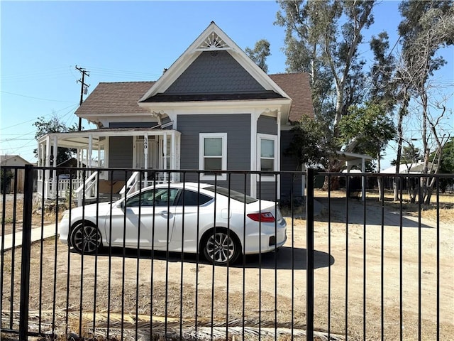 340 E Main St, San Jacinto, CA 92583 - view of front of house featuring a porch, a fenced front yard, and a shingled roof