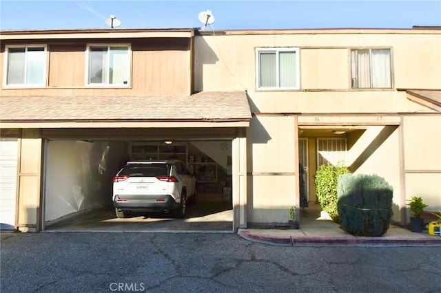 12828 Ramona Blvd Unit 96, Baldwin Park, CA 91706 - view of front of house with driveway, a garage, and a shingled roof