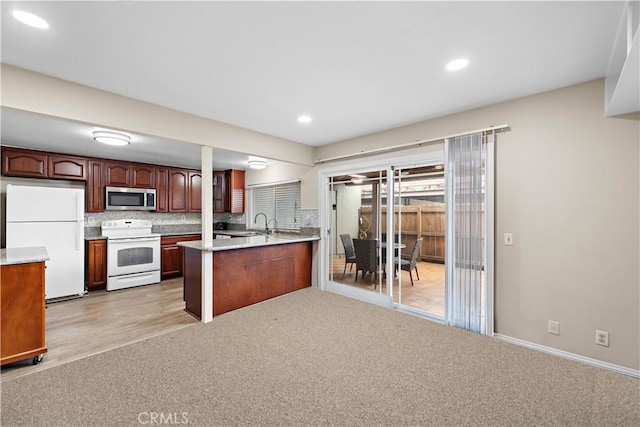 4690 Larwin Ave, Cypress, CA 90630 - kitchen with white appliances, a peninsula, light countertops, tasteful backsplash, and light carpet