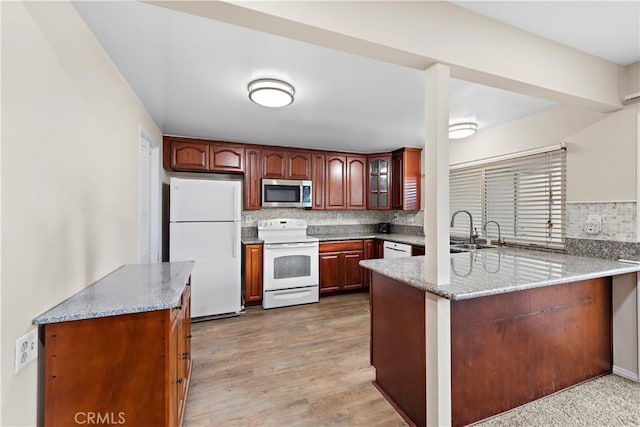 4690 Larwin Ave, Cypress, CA 90630 - kitchen featuring white appliances, a peninsula, decorative backsplash, light stone counters, and glass insert cabinets