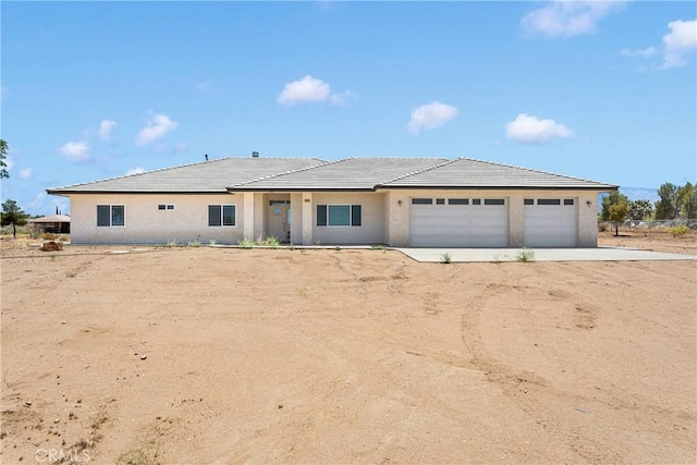 6643 Avenal St, Phelan, CA 92371 - view of front of property with driveway, an attached garage, and stucco siding