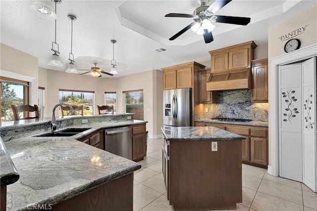 6643 Avenal St, Phelan, CA 92371 - kitchen with stainless steel appliances, a large island with sink, a ceiling fan, a tray ceiling, and decorative backsplash