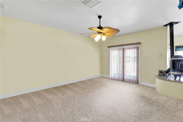 6643 Avenal St, Phelan, CA 92371 - unfurnished living room with a wood stove, carpet floors, and a ceiling fan