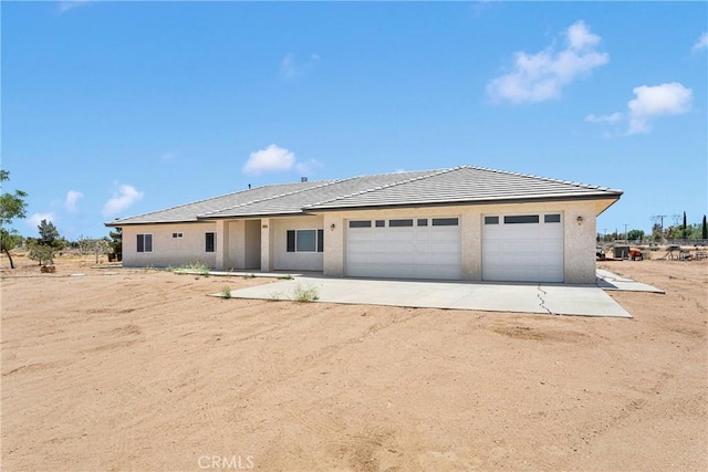 6643 Avenal St, Phelan, CA 92371 - view of front facade featuring dirt driveway, a garage, stucco siding, and a tiled roof