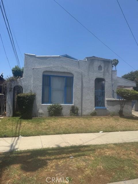 8463 S Halldale Ave, Los Angeles, CA 90047 - mediterranean / spanish-style house featuring stucco siding and a front lawn