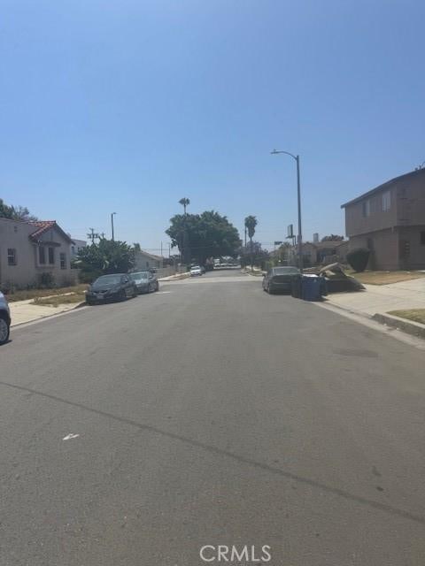 8463 S Halldale Ave, Los Angeles, CA 90047 - view of asphalt road with sidewalks, curbs, and street lighting