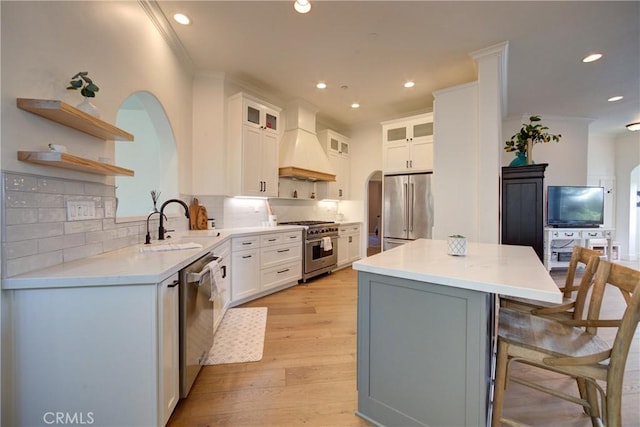 1910 Fixlini St, San Luis Obispo, CA 93401 - kitchen with appliances with stainless steel finishes, custom range hood, a kitchen island, open shelves, and arched walkways