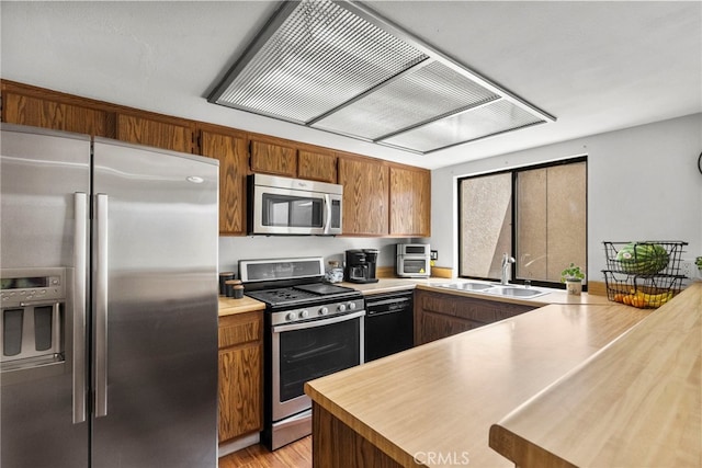 15230 Roxford St Unit 61, Sylmar, CA 91342 - kitchen featuring appliances with stainless steel finishes, ventilation hood, a peninsula, and light countertops