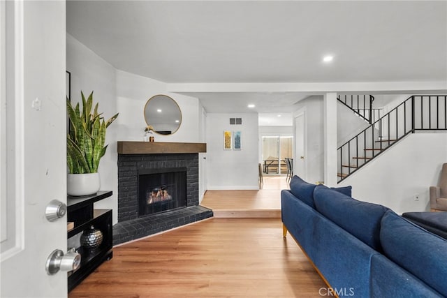 15230 Roxford St Unit 61, Sylmar, CA 91342 - living area with wood finished floors, a brick fireplace, stairway, and recessed lighting