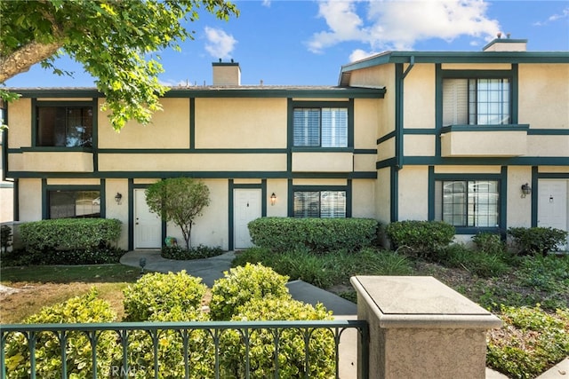 15230 Roxford St Unit 61, Sylmar, CA 91342 - view of front of home with stucco siding and a chimney
