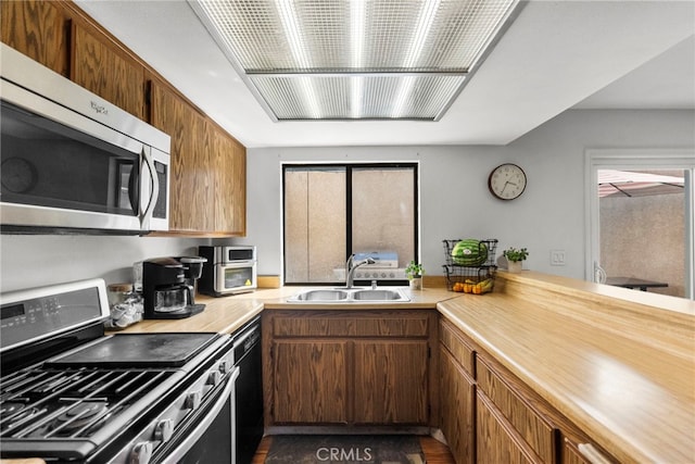 15230 Roxford St Unit 61, Sylmar, CA 91342 - kitchen with stainless steel appliances, light countertops, and brown cabinets
