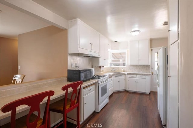 310 E Forhan St, Long Beach, CA 90805 - kitchen featuring white appliances, light countertops, white cabinets, dark wood-style floors, and tasteful backsplash