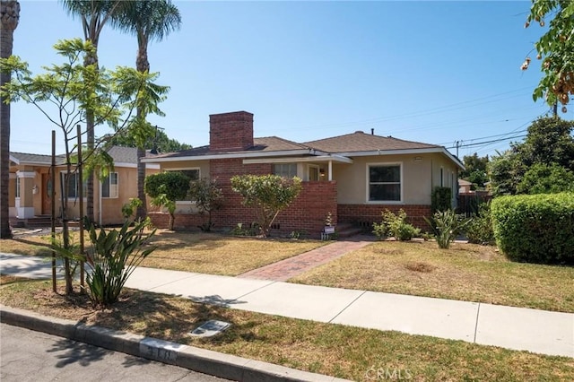 310 E Forhan St, Long Beach, CA 90805 - view of front facade with brick siding, stucco siding, a front lawn, and a chimney