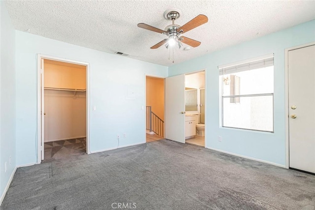 12411 Osborne St Unit 114, Pacoima, CA 91331 - unfurnished bedroom with carpet flooring, a textured ceiling, a walk in closet, ensuite bath, and a ceiling fan