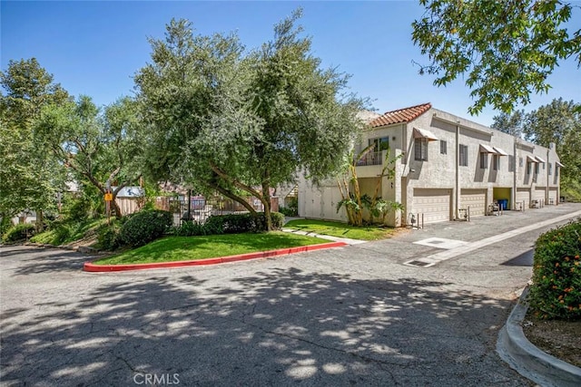 12411 Osborne St Unit 114, Pacoima, CA 91331 - view of property featuring an attached garage, driveway, and a residential view